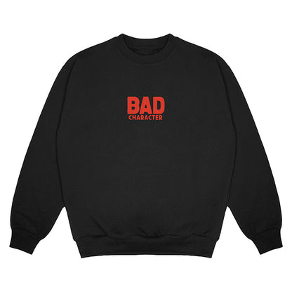Front view of black crewneck sweater with small red Bad Character logo printed on front chest