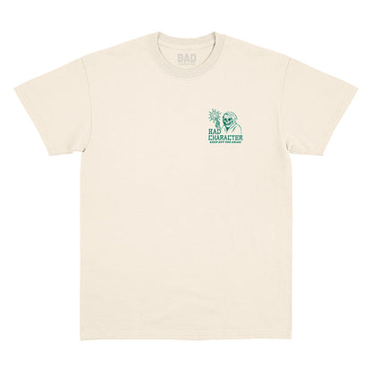 Front view of natural t-shirt with small ‘Bad Character’ left chest print and ‘Keep Off the Grass’ graphic