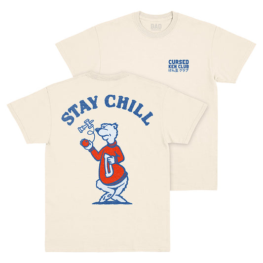 Front and back views of natural t-shirt with small blue Cursed Ken Club wordmark on left chest and ‘Stay Chill’ bear mascot graphic on back 
